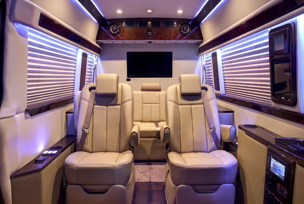 Custom Mercedes-Benz Sprinter cabin with cream leather seating under LED ceiling lighting